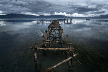 Endonezya 'nın Sumatra kentindeki Toba Gölü' nde, fırtınadan ve tekneden sonraki sakin anlarda balıkçı çok uzaklardan yaklaşıyor..