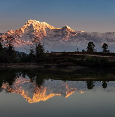 Annapurna sıradağları Nepal, Panchase köyündeki küçük göle yansıdı.