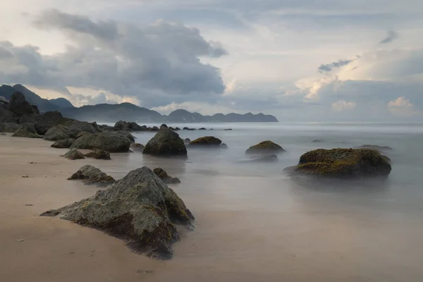 Beyaz bir kumsal manzarası ve Aceh bölgesindeki tropik Sumatra adasının engebeli kayalık kıyı şeridi, Lhoknga plajı.