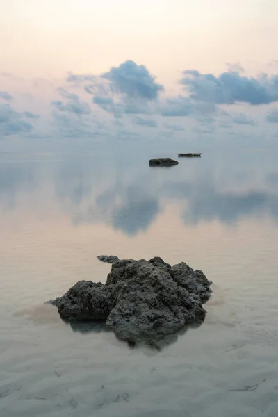 Havelock ya da Swaraj Dweep adasındaki kayalar ve gökyüzü Andaman Denizi 'nin camsı sularına yansıyor.