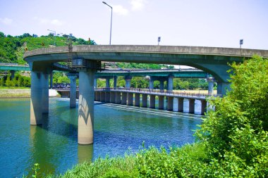 Jungnang Irmağı 'nın ağzında Ipsokpo' nun huzurlu güzelliğini yakalayan bu sakin sahne Seul, Ichon Hangang Parkı 'nda gözler önüne seriliyor. Kıvrımlı yokuş ve köprü zarif bir şekilde suyun üzerinde kavis çiziyor, doğanın ve şehirin uyumlu karışımını sembolize ediyor
