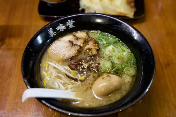 Lezzetli bir kase ramen, ustalıkla suda haşlanmış yumurta, üstünde leziz et ve lezzetli bir ziyafet yaratacak şekilde mükemmel pişirilmiş erişte..