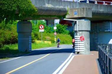 Seul, Güney Kore - 2 Haziran 2023: Bir bisikletçi Jamwon Hangang Parkı 'ndaki Seongsu Köprüsü' nün alçak rampasının altında bisiklet yolu boyunca manevra yapıyor..