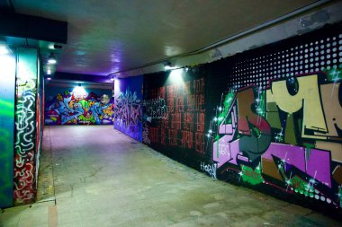 Seul, Güney Kore - 2 Haziran 2023: Grafiti kaplı duvarların parlak spot ışıklarıyla aydınlatıldığı Apgujeong Tavşan Mağarası 'nın dönüşlerinde gezinmek, canlı bir sanat deneyimi yaratıyor..