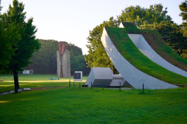 Seul, Güney Kore - 2 Haziran 2023 Olimpik Park Heykel Parkı 'nda sakin bir sabah, çimen tepeli eşsiz bir beton heykel ve Stonehenge' e benzeyen yüksek bir taş heykel.