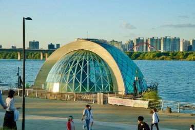 Seul, Güney Kore - 3 Haziran 2023: Han Nehri 'ndeki Waterlight Sahnesi, belirgin cam önü ile Bamseom Adası ve Seongang Köprüsü' nün arka planına karşı sakin bir manzara sunuyor..