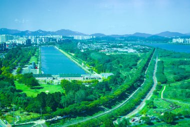 Hanam City, Güney Kore - 1 Ekim 2023: Hanam Union Kulesi 'nin tepesinden geniş bir hava perspektifi, Misa Tekne Parkı' nın nehir kenarındaki bisiklet yolunun yanındaki dikdörtgen gölünü gösteriyor..
