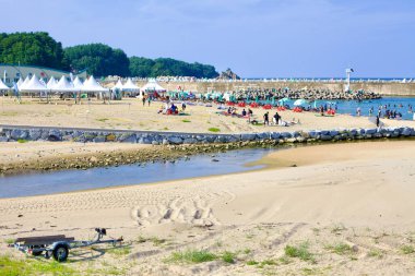 Yangyang İlçesi, Güney Kore - 30 Temmuz 2019: Gisamun Sahili, yaz sonu güneşi altında kalabalıklar ve çadırlarla canlanıyor..