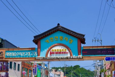 Goseong İlçesi, Güney Kore - 30 Temmuz 2019: Geojin Limanı 'ndan geçen Geojin Geleneksel Pazarı' na girişi gösteren mavi bir tabela, yerli halkı ve ziyaretçileri hareketli tezgahları ve yerel ürünleri keşfetmeye çağırıyor