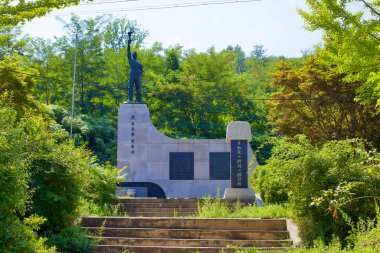 Goseong İlçesi, Güney Kore - 31 Temmuz 2019: Goseong Birleşme Gözlemevi 'nin resepsiyon binasının yakınında, granit bir kaidede duran heykel, elinde meşale tutan bir adamı temsil ediyor, Kore' nin yeniden birleşme umudunu simgeliyor.