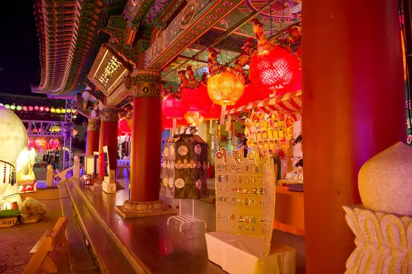 Ulsan, Güney Kore - 15 Mayıs 2024: Jeonggwangsa Tapınağı 'nın girişinde kırmızı sütunlar ve Çin Budist tabelası bulunmaktadır. Kırmızı fenerler yukarıda asılı, Buda 'nın doğum günü kutlamalarında ziyaretçileri karşılıyorlar..