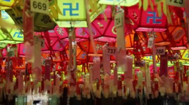 Ulsan, Güney Kore - 15 Mayıs 2024: Jeonggwangsa Tapınağı 'nın dışında, üzerinde Buda olan renk değiştiren bir ejderha fenerinin 4K' lık geniş eğim ve tava görüntüsü. Büyük ejderhanın kolları ve başı renkler değiştikçe hareket eder.