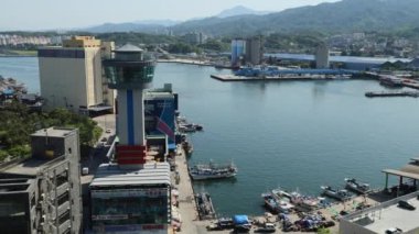 Donghae Şehri, Güney Kore - 18 Mayıs 2024: Nongoldam Caddesi 'ndeki bir gözlem güvertesinden Mukho Limanı' nın uzun dalgakıranlarını tetrapodlarla, Mukho Limanı Gözlemevi yüksek kulesiyle ve depolarla yakalayan bir sol çekim.