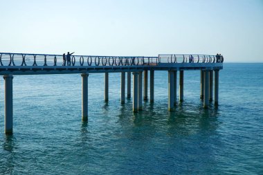 Gangneung, Güney Kore - 18 Mayıs 2024: Ziyaretçiler Jeongdongjin 'deki Sun Cruise Resort yakınlarındaki yüksek yürüyüş ve gözlem güvertesinde huzurlu bir anın tadını çıkarıyorlar..