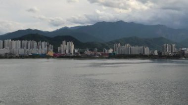 Sokcho, Güney Kore - 28 Temmuz 2024: 15 saniyelik bir 4K videosu, Seorak Grand Bridge 'den Cheongcho Gölü' nün geniş bir görüntüsünü yakalar ve Sokcho 'nun ufuk çizgisini yemyeşil dağların arka planında gösterir..