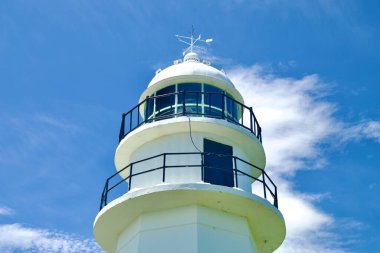 Uljin County, Güney Kore - 27 Temmuz 2024 Hupo Deniz Feneri 'nin tepesindeki fener odasının çarpıcı bir yakın görüntüsü, rüzgâr gülünü canlı mavi bir gökyüzü ve ince bulutların arka planında görülebiliyor..