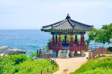 Uljin County, South Korea - July 27th, 2024: A picturesque traditional Korean pavilion perched on a cliff in Deunggi Mountain Park offers visitors a serene view of the East Sea, blending cultural heritage with natural beauty. clipart