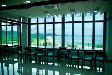 Goseong County, South Korea - July 28th, 2024: The lobby of a building adjacent to the Unification Observatory offers seating with panoramic views of the DMZ coastline and Mount Kumgang in the distance, providing a peaceful observation area. clipart