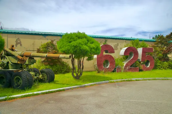 stock image Goseong County, South Korea - July 28th, 2024: An outdoor display outside the 6.25 War Experience Exhibition Hall, featuring a large artillery gun and prominent 