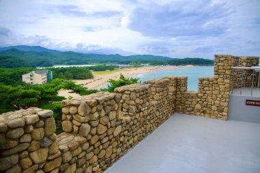 Goseong County, South Korea - July 28, 2024: The stone parapets on the rooftop of Kim Il-Sung's Villa offer a commanding view of Hwajinpo Beach and the surrounding landscape, blending historic architecture with scenic vistas of the East Sea. clipart