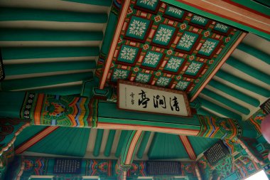 Goseong County, Güney Kore - 28 Temmuz 2024: Cheonggan Pavyonu 'nun karmaşık tavanı Joseon Hanedanı' nın sanatsal ve kültürel mirasını yansıtan canlı, geleneksel Kore desenleri ve renklerini sergiliyor..