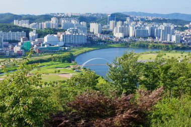 Ulsan, Güney Kore - 14 Haziran 2018: Taehwa Nehri üzerinde aydınlanan Simnidaebat Köprüsü manzarası, arka planda Ulsan kenti ile birlikte Taehwa Nehri Ulusal Bahçesi 'ne doğru ilerliyor..