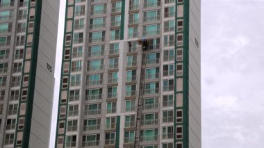 Ulsan, Güney Kore - 27 Ekim 2024: Bu 4K videosu bir apartman dairesi boyunca inen bir merdiven kamyonu platformunu gösteriyor..