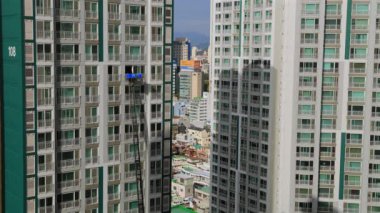 Ulsan, Güney Kore - 27 Ekim 2024: Yakındaki bir binanın 24. katından çekilen bu 4K videosu, eşyaları yüksek katlı bir apartman penceresine taşıyan bir merdiven kamyonunu gösteriyor..