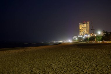 Gangneung, Güney Kore - 3 Kasım 2024: Seamarq Hotel 'in aydınlatıldığı Gyeongpodae Sahili gece manzarası. Huzurlu, loş kıyı şeridi kıyı sahnesinin sakin atmosferini vurguluyor..