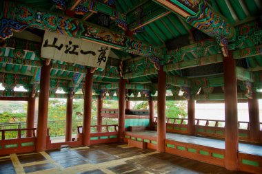 Gangneung, Güney Kore - 3 Kasım 2024: Gyeongpodae Pavyonu 'nun iç kesiminde canlı boyanmış detaylar, süslü kirişler ve çevre manzaraya açık manzaralı geleneksel Kore ahşap mimarisi yer almaktadır..