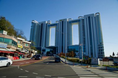 Sokcho, Güney Kore - 3 Kasım 2024: Daepo Limanı yakınlarındaki Cassia Sokcho Oteli 'nin manzarası, yakındaki geleneksel dükkanlar ve yerel işletmelerle çelişiyor..