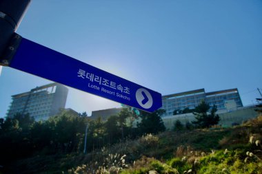 Sokcho City, Güney Kore - 3 Kasım 2024: Lotte Resort Sokcho 'yu işaret eden bir yön tabelası açık bir gökyüzüne karşı duruyor..