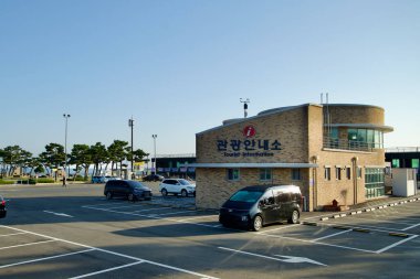 Sokcho, Güney Kore - 3 Kasım 2024: Seorak Sunrise Park 'taki turizm bilgi merkezinin yanında manzaralı kıyı bölgesini keşfeden ziyaretçilere uygun erişim ve rehberlik sunan geniş bir otopark.