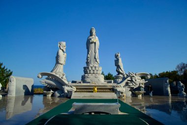 Yangyang İlçesi, Güney Kore - 3 Kasım 2024: Avalokitesvara heykeli, Huyuam Hermitage 'da huzur verici bir ruhani ortam yaratan, karmaşık bir şekilde oyulmuş ejderha üssü üzerinde duruyor..