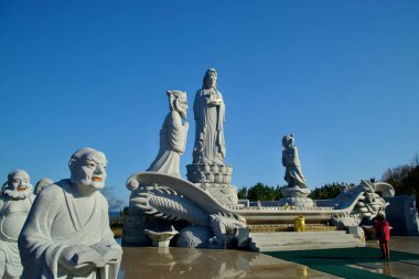 Yangyang İlçesi, Güney Kore - 3 Kasım 2024: Huyuam Hermitage 'da karmaşık oymalar ve sembolik ejderha motiflerinin yer aldığı Avalokitesvara heykelinin ayrıntılı bir görüntüsü.