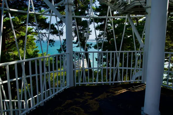 Yangyang İlçesi, Güney Kore - 3 Kasım 2024: Çam ağaçları ve kıyı manzarasıyla çevrili Jukdo Dağı Gözlemevi 'nin beyaz metal yapısı tarafından çerçevelenmiş Doğu Denizi' nin çarpıcı manzarası.