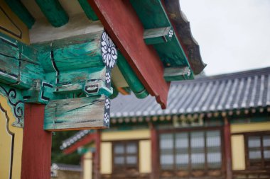 Goesan County, South Korea - September 10, 2020: A close-up of the vibrant wooden eaves at Yeonpung Hyanggyo, showcasing traditional Korean architectural details and faded dancheong patterns on this historic Confucian school. clipart