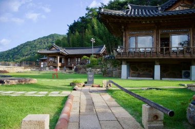 Gokseong İlçesi, Güney Kore - 3 Ekim 2021: Yeşillik ortamda geleneksel Kore mimarisini modern bir rahatlama alanı ile harmanlayan, bakımlı bir bahçesi olan büyüleyici bir hanok tarzı kafe.