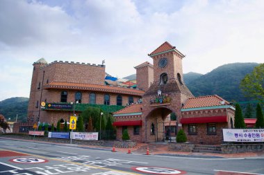 Gurye County, Güney Kore - 3 Ekim 2021: Avrupa tarzı bir tuğla bina olan Aprok Hayalgücü Okulu Yalu Köyü 'nde yol boyunca duruyor. Saat kulesi ve şato benzeri tasarımı onu eşsiz bir cazibe merkezi haline getiriyor..