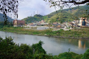Gurye İlçesi, Güney Kore - 3 Ekim 2021: Seomjin Nehri boyunca Yalu Köyü manzarası, tepeler, geleneksel evler ve modern yapılar Kore 'nin bu kırsal kesiminin geçmişiyle bugünün karışımını yansıtıyor..