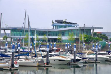 Incheon, Güney Kore - 19 Mayıs 2025: Ara Marina 'nın gösterişli, modern tesisi, Kuzey Incheon' daki Ara Waterway boyunca uzanan canlı bir eğlence limanı olan C iskelesine demirlemiş yatların üzerinde yükseliyor..