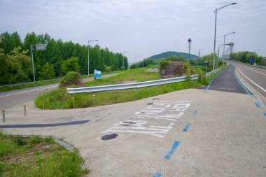 Incheon, Güney Kore - 19 Mayıs 2025: Jeonho Köprüsü 'nden Ara Hangang Kilidi ve Gyeongin Ara Su Yolu boyunca kanal seviyesindeki tesislere doğru işaretli bir bisiklet yolu ayrılır..