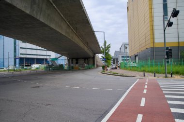 Incheon, Güney Kore - 19 Mayıs 2025: Ara Bisiklet Yolu 'nun bir bölümü endüstriyel bir caddeden geçiyor ve Hana Köprüsü' nün yüksek yapısının altından geçiyor..