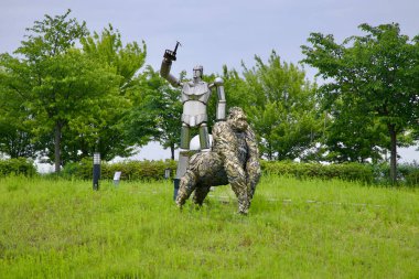 Incheon, Güney Kore - 19 Mayıs 2025: Endüstriyel sanat formlarıyla doğayı harmanlayan, Ara Su Yolu 'ndaki bir heykel parkındaki çimenli bir alanda şekillendirilmiş goril ve insansı robot duruşu.