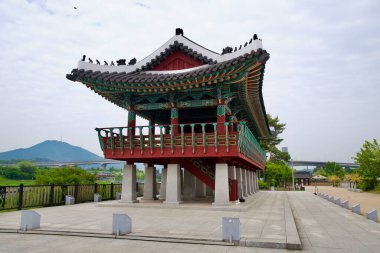 Incheon, Güney Kore - 19 Mayıs 2025: Yüksek Suhyangwon Pavyonu Daecheong Dağı ve Ara Su Yolu 'na bakıyor, canlı dancheong desenleri ve nehir kenarındaki bir platformda geleneksel Kore inşaatı sergiliyor..
