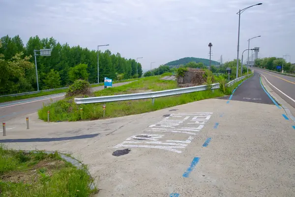 Incheon, Güney Kore - 19 Mayıs 2025: Jeonho Köprüsü 'nden Ara Hangang Kilidi ve Gyeongin Ara Su Yolu boyunca kanal seviyesindeki tesislere doğru işaretli bir bisiklet yolu ayrılır..