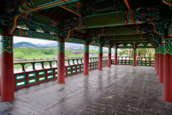 Incheon, Güney Kore - 19 Mayıs 2025: Suhyangwon Pavyonu 'nun içinden Ara Waterway ve çevreleyen yeşil tepelerin geniş bir manzarası dancheong tavanlarını ve yapının boyalı sütunlarını tamamlıyor.