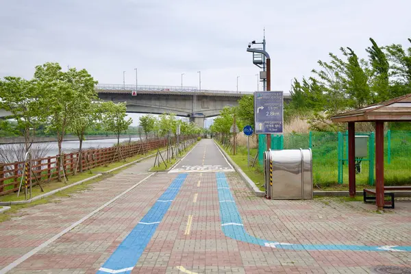Incheon, Güney Kore - 19 Mayıs 2025: Ara Bisiklet Yolu boyunca belirlenmiş bir mola yeri ve yol bulma levhası Ara Batı Deniz Kilidi ve Incheon Terminali gibi yakınlardaki noktalara bisikletçileri işaret ediyor..