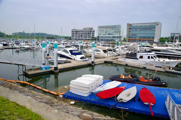 Incheon, Güney Kore - 19 Mayıs 2025: Bir yat, sürat teknesi ve eğitim gemisi koleksiyonu Ara Marina 'nın kaydırağında duruyor, ön planda yüzen bir rıhtımda küçük yelkenliler ve botlar depolanmış..