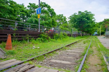 Overgrown railroad tracks from the old Gyeongchun Line run alongside a raised bike parking deck at Neungnae, blending Koreas rail history with modern cycling infrastructure.